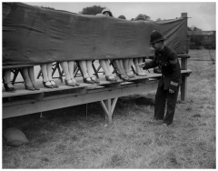 A police officer judges an ankle competition in London. [1930]